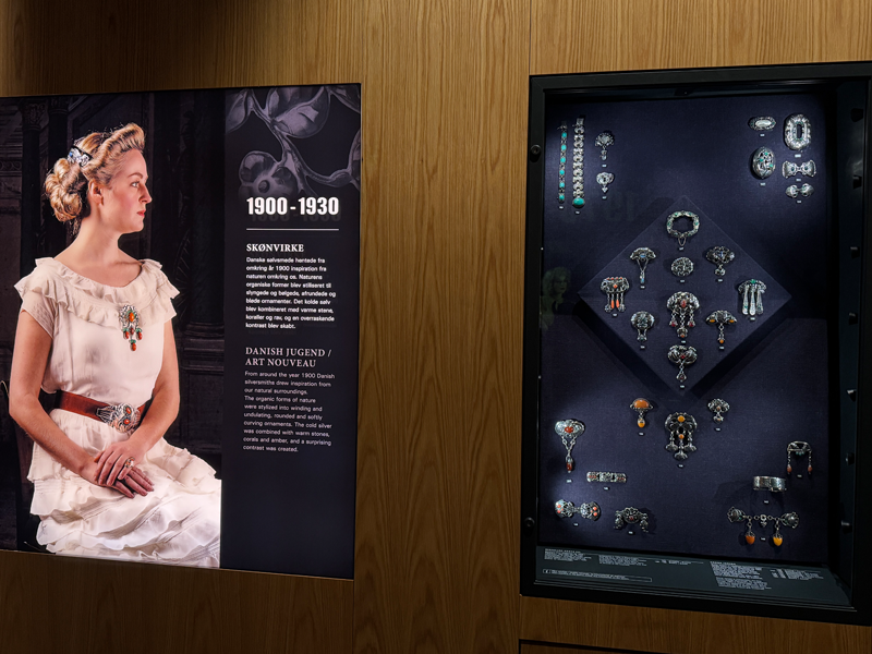 1900-1930 jewellery on a model and next to it examples in a exhibit