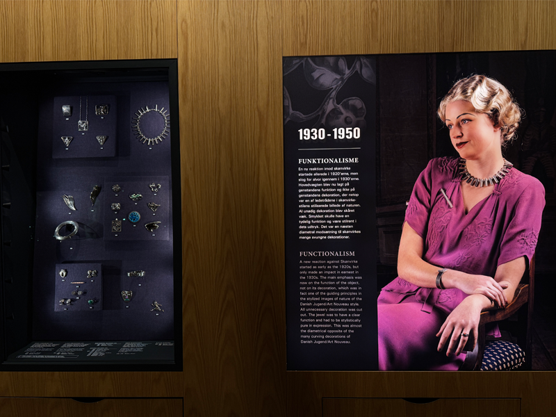 1930-1950 jewellery on a model and next to it examples in a exhibit